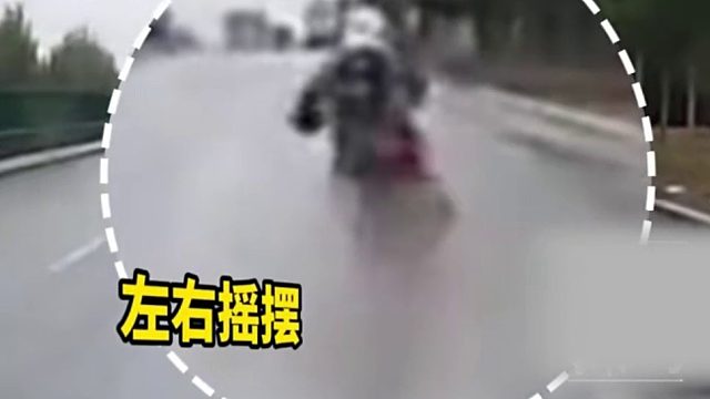 雨天摩托车经过积水路段时，车子左右扭动差点翻车！
