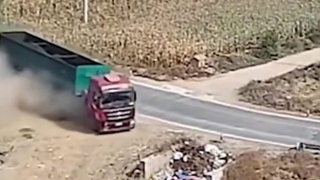 为避让路中间停放的三轮车，大货车一头冲向路边垃圾堆！