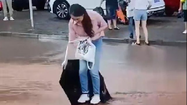 女子为了不打湿鞋，踩伞过马路。伞：终究是我抗下了所有…