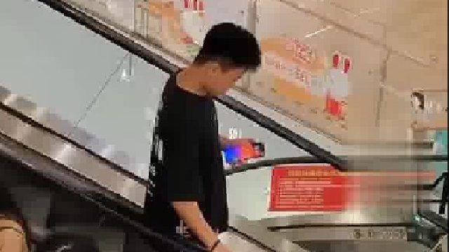 女子在商场扶梯摸路人的手，小伙上前打手制止.....