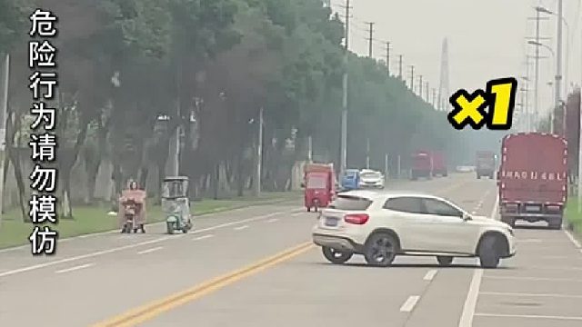 轿车在马路中央不停转圈，过路车辆只能停下等待！