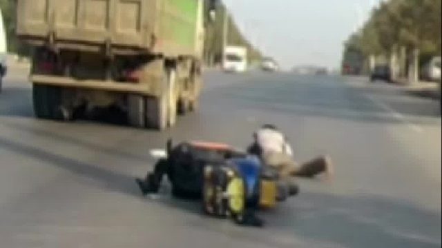 一骑车男子被掉落的电线绊倒，凌空旋转摔倒在地头盔被甩飞！