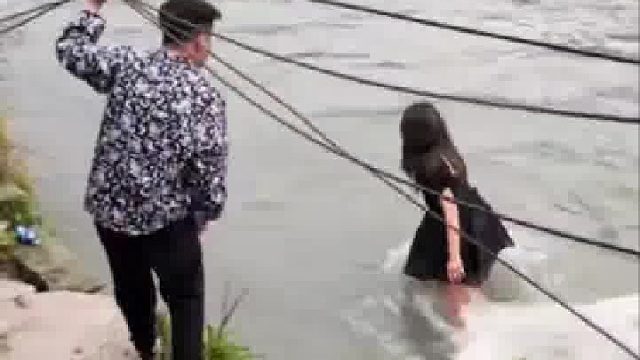 一对男女争吵后女子下到河里，一步一步往河中间走