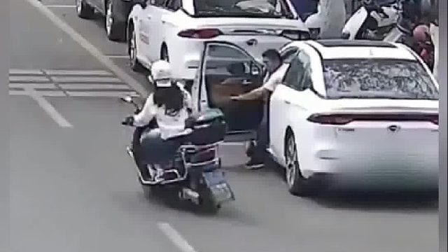 男子车辆停靠路边开车门，导致骑电动车女子摔倒！