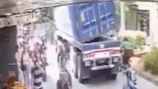 集装箱货柜车行驶在路中突然货柜掉下，好在路人及时躲避！