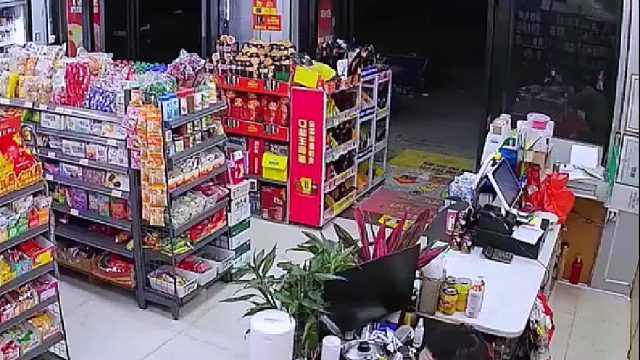 老板坐在桌子前看手机，被突然窜上来的猫咪吓一跳