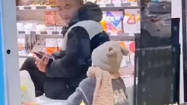 宝宝站在窗户外盯着店里叔叔的零食，叔叔见状细心挑了一个给宝宝，宝宝下意识接直接把手放到了窗户上