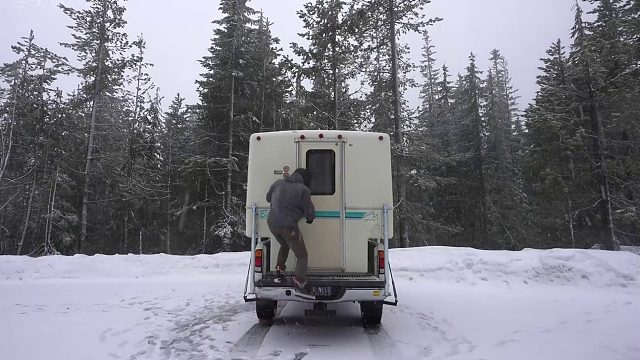 年轻小伙在下雪天前往野外露营