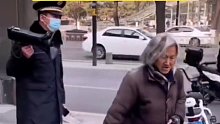 大妈装穷路边乞讨，工作人员拿喇叭在身后 硬核提醒路人-