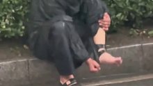 下雨路滑，男子的拖鞋滑到脚脖上拽不下来！