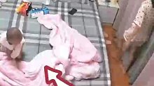 担心孩子从床上掉下来，妈妈飞奔冲上前保护却摔伤自己。