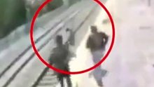 火车进站瞬间女孩跳下站台轻生，路过小伙百米冲刺飞扑救下
