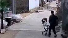 监拍宝爸带娃出门遛弯，不知道被什么吸引了目光，童车被大风吹走竟不知道