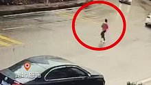 女子跑着横穿马路。路面湿滑，私家车急刹漂移，差点撞上女子。