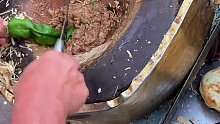 山东菏泽，大叔卖肉夹馍27年，用了18年的案板被剁出深坑。