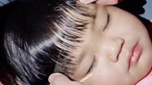 爸爸趁女儿熟睡，为其剪刘海