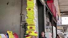 工人大哥肩扛20袋米，高高的米袋如山一般…