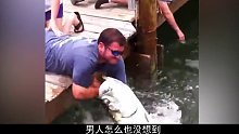 男人湖边喂鱼，不慎被大鱼咬住了手臂！