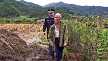 民警帮老人收割稻谷。