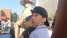 女子骑车孩子坐在后座吃串，后车男子善意提醒不能吃，很危险