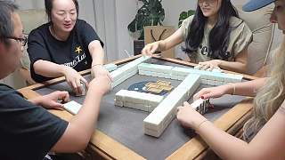 玩家麻將桌旁拿起打火機(jī)