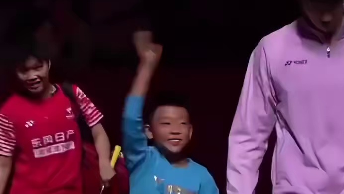 12月20日，2025年世界羽联年终总决赛迎来半决赛，羽毛球运动员黄东萍入场时牵着球童艾登。 ​​​