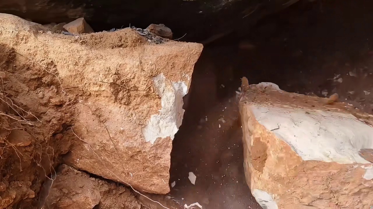 男人在野外发现一个石洞，用火烧出一个庇护所