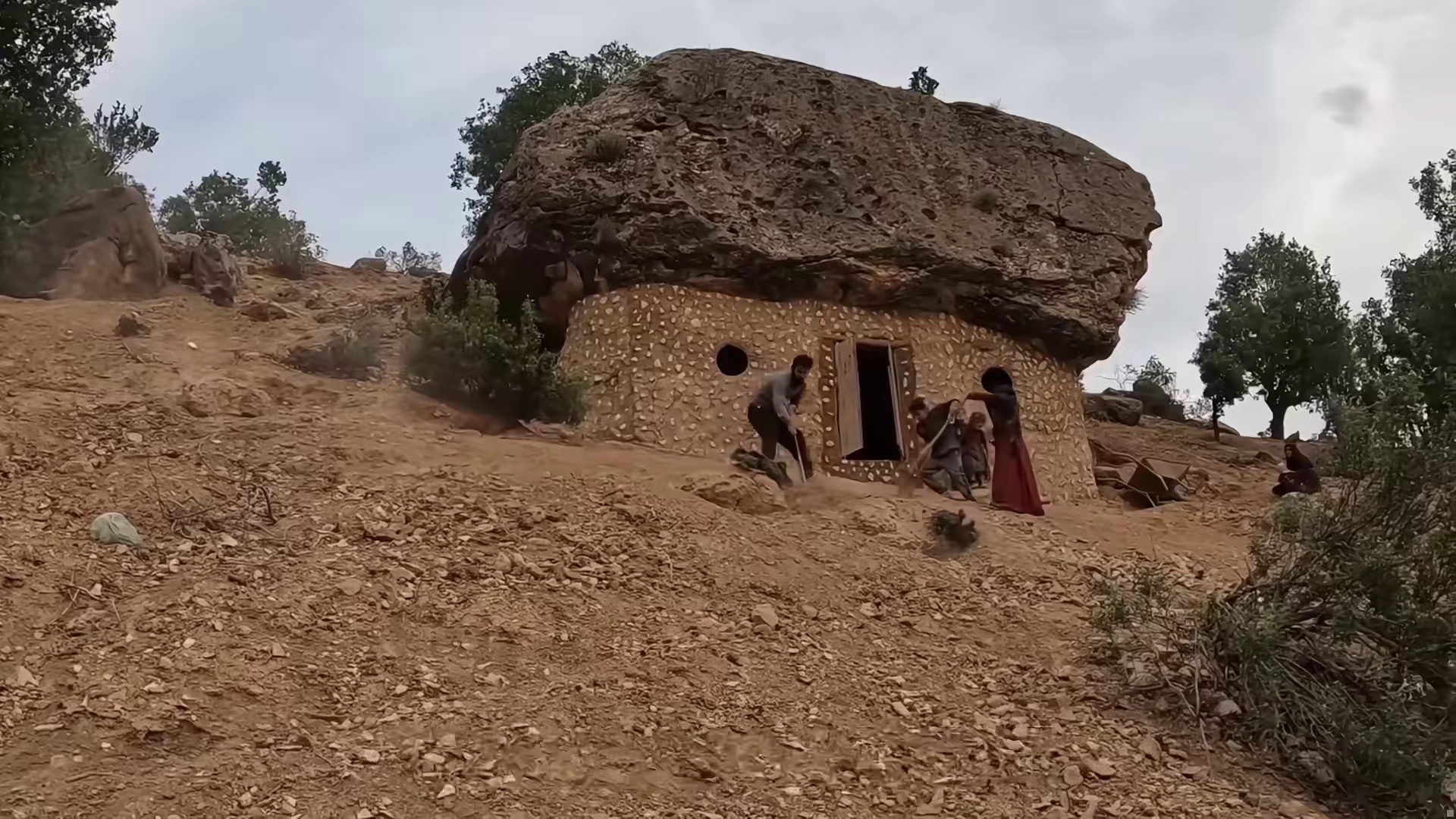 游牧一家在迁徙途中找到水源，就地在巨石下建造庇护所，住上一家八口人