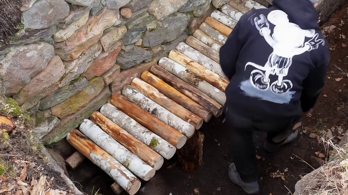 在野外，男人将废弃的地基搭建成了温暖的小屋