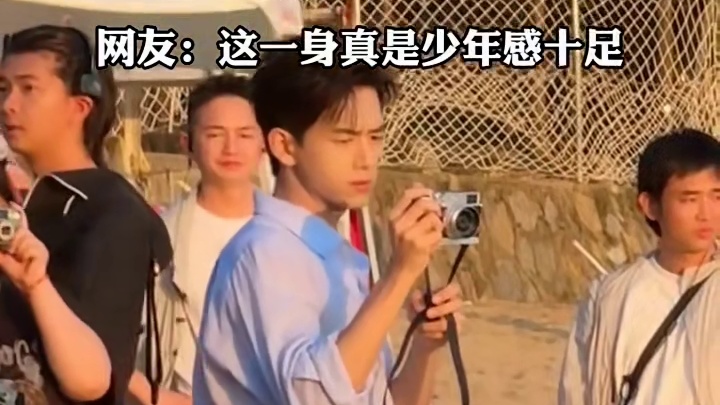 网友旅游时偶遇李现 ，拍摄之余也不忘拿起相机拍风景 ，网友:这一身真是少年感十足