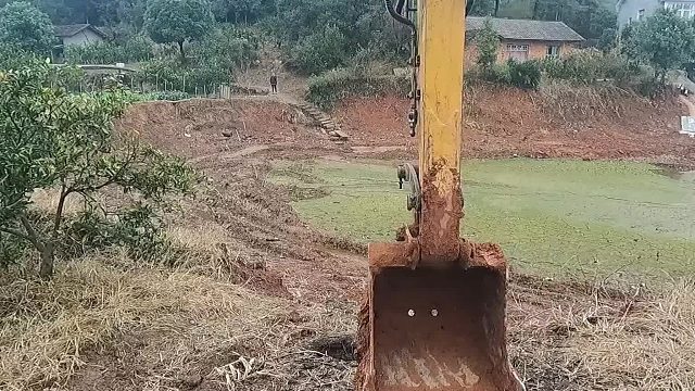 鱼塘里面有很深的槽，不好拉鱼。挖机过来弄一下