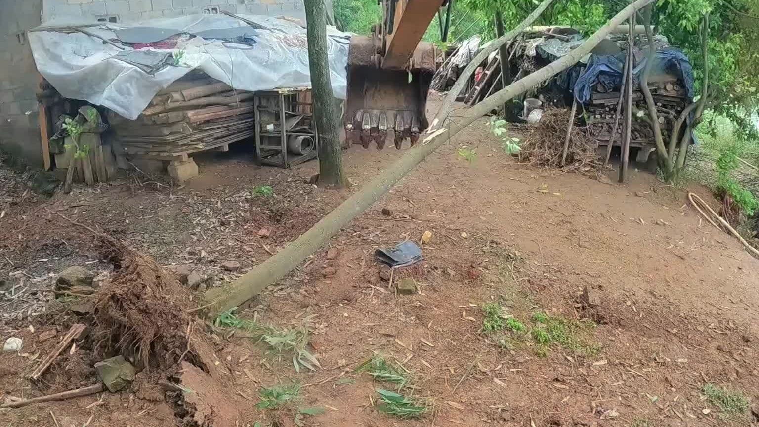 屋后面有一堆土挡着，水流不出去。喊挖机过来挖通。