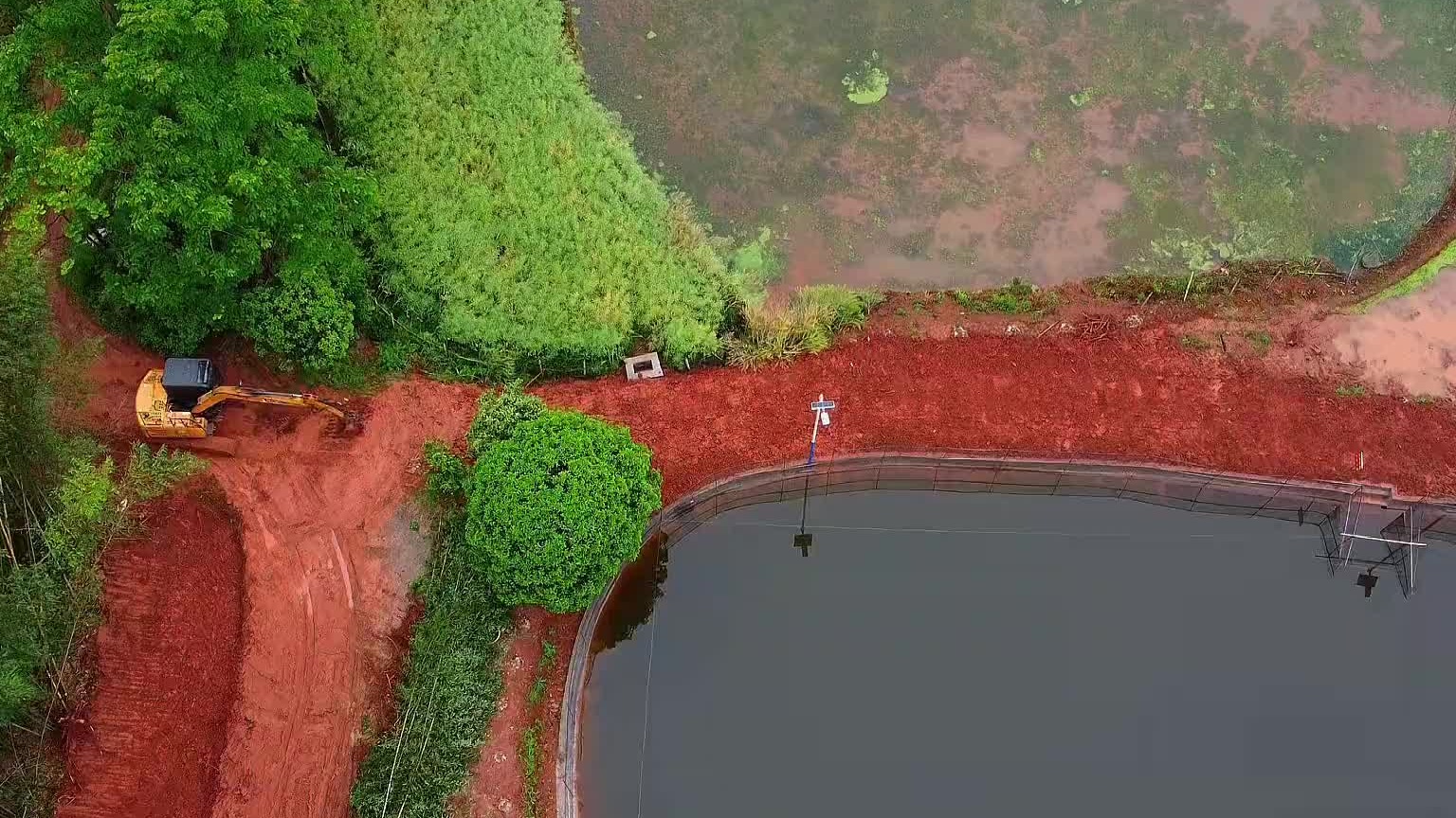 鱼塘堤坝拖土加高。喊你干个活，不是吹风就是下雨。