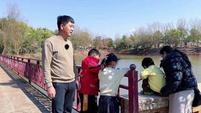 一家三口去钓鱼，引来小朋友围观，吓得大鱼不敢上钩