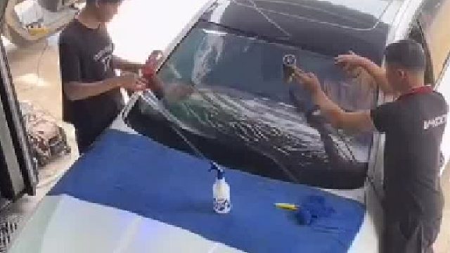 店里员工在给车贴膜，不料车主误把雨刮器打开了！