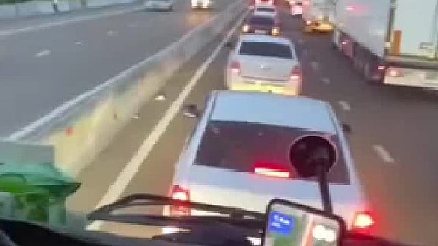 路上堵车排起长龙，三人从对向车道倒着走