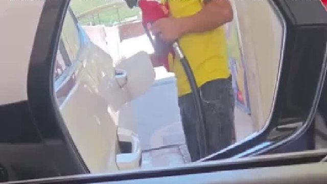 加油员用小伎俩想骗车主，没想到车主一直盯着后视镜看他