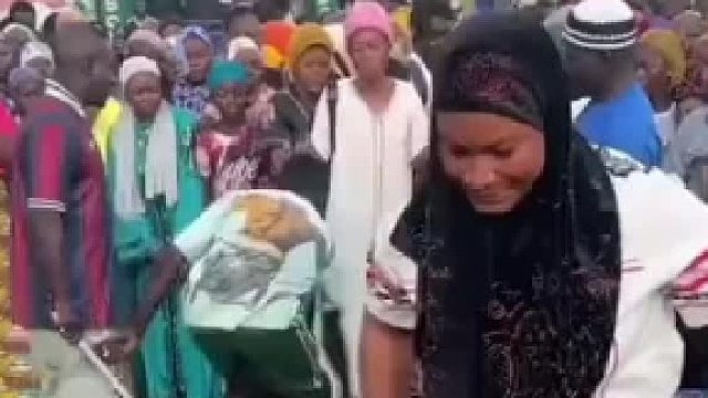 这个非洲女人力气真大，这么大一桶水直接放头顶上了。