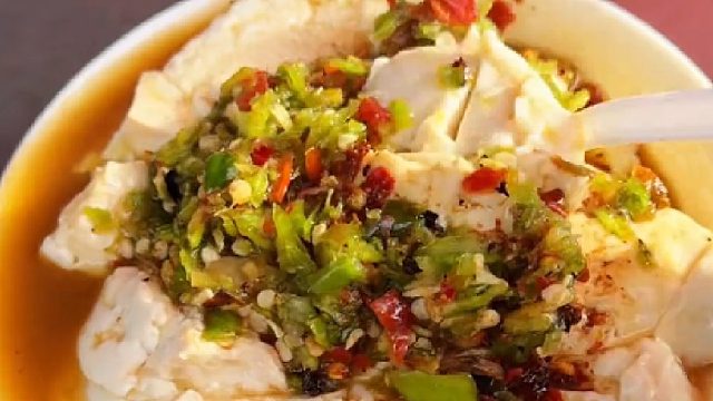 江苏徐州路边卖豆腐的阿姨，一天做两大包豆腐，两元一碗，加上简单的青红椒，一会就卖完了，