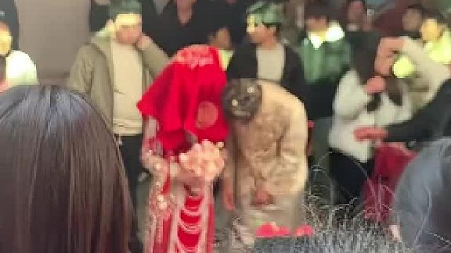 一对新人结婚新娘顶着红盖头，突然一个大妈把盖头扯下来了