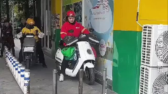 外卖小哥被铁杆拦住，直接把电动车扛起来通过