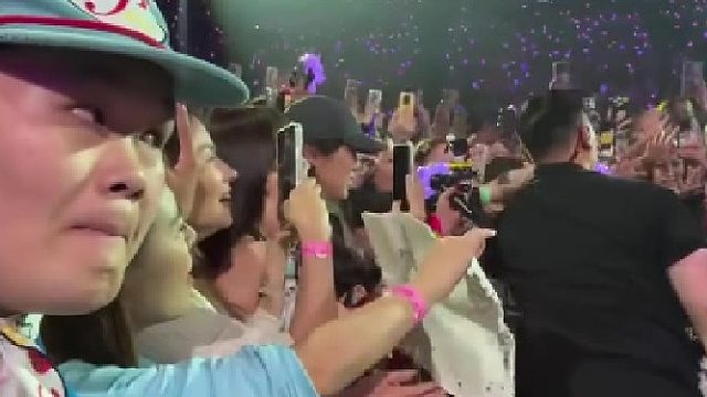 权志龙演唱会上，权志龙戴粉丝帽子唱歌