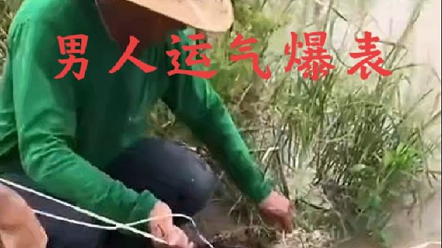 男人手持砍柴刀并用绳钩抓捕河岸神秘生物