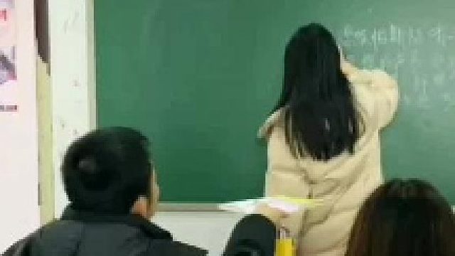 老师正在擦黑板，前排学生下意识动作让人直呼感动