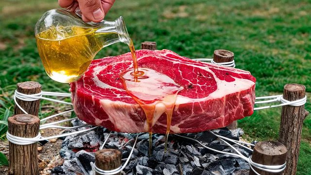 在手工制作的森林烤架上烹饪巨型牛排_ Bushcraft 户外烹饪
