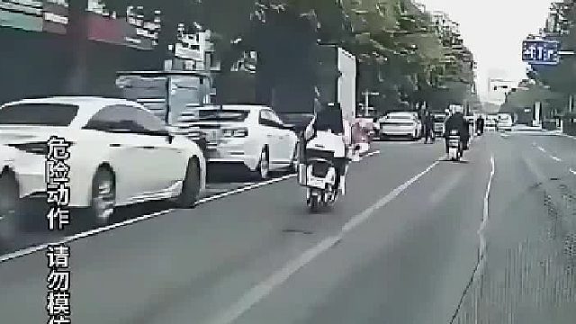 女子骑车在公路呈S形行驶，随后撞上护栏