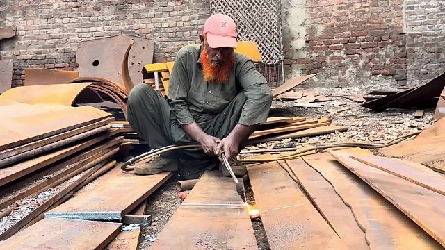 巴基斯坦工人利用轮船钢板制作钢钉