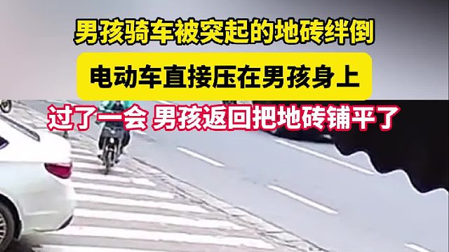 男孩骑车被突起的地砖绊倒 电动车直接压在男孩身上 过了一会男孩返回把地砖铺平了