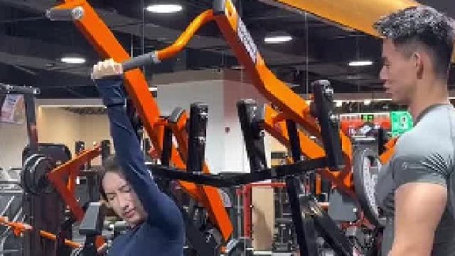 女子假装拉不动健身器材，教练假装换杠铃片女子立马就能拉动了