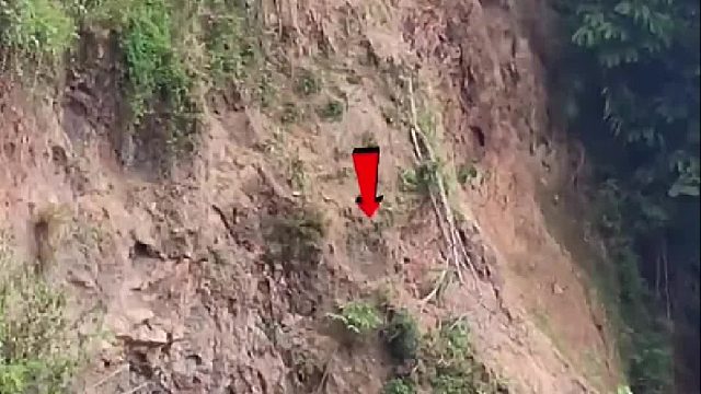 男子竟然盘坐在即将山体滑坡的山脚下钓鱼